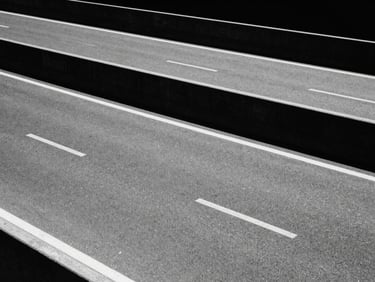 Stark minimalist composition of an empty concrete highway under harsh direct sunlight, deep black shadows, 35mm film