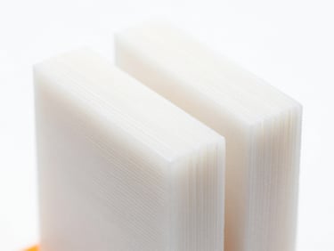 Extreme close-up of a flawless technical 3D print showing perfect layer adhesion, white background, bright studio lighting