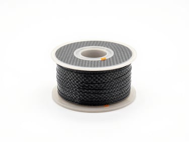 Pristine carbon fiber filament spool on a clean white surface, high-key studio light, orange accent details