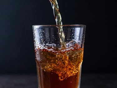 Fresh cold water pouring into a clear glass with condensation, bright splash, dark background with subtle blue highlights