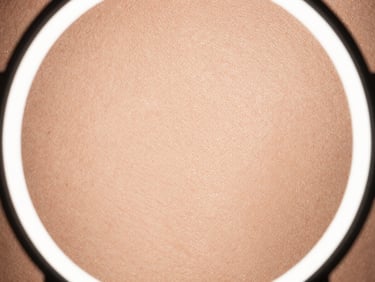 Extreme macro close-up of flawless real skin texture under professional studio ring light, showcasing detailed pores and fine champagne-gold shimmer, no digital blurring.