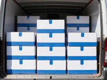 Bright editorial photography of an organized moving truck with neatly stacked branded boxes, crisp natural daylight, clean blue and white tones, sharp focus, 35mm
