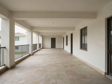 Wide shot of a building common area corridor in a residential property, empty, clean, neutral daylight from side windows, architectural framing showing structural elements and flooring condition, no people