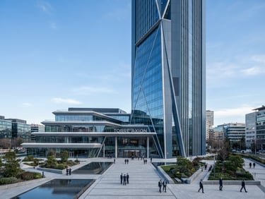 Wide architectural shot of a modern corporate headquarters in Madrid, cool crisp daylight, clean lines, slate blue tones, professional and authoritative atmosphere