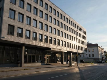 Aukštos klasės verslo centro Vilniuje fragmentas, švari natūrali šviesa, atspindžiai stikliniame fasade, moderni architektūra.