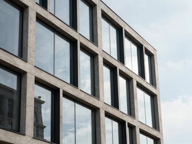 Clean diffused daylight architectural close-up of a modern concrete and glass commercial building facade in Vilnius, sharp geometric lines, reflection of sky
