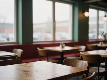 Cozy Scandinavian-style restaurant interior during mid-afternoon prep, empty wooden tables, soft overcast light through large windows, warm editorial photography, 35mm