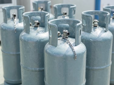 Steel high-pressure gas cylinder secured with safety chains in a clean workshop, bright daylight