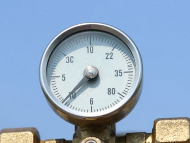 Close up of a polished brass gas regulator dial, clean metallic textures, safety blue background, sharp focus