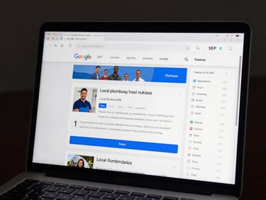 Tight crop of a laptop screen showing a Google SERP with a local plumbing business website highlighted in position one, before-and-after rank delta visible in a sidebar analytics panel, screen glow lighting, dark background