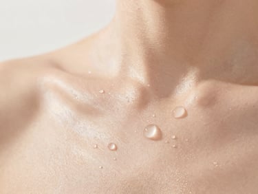 Close-up of clean, glowing skin texture with water droplets, soft natural daylight, minimalist editorial style
