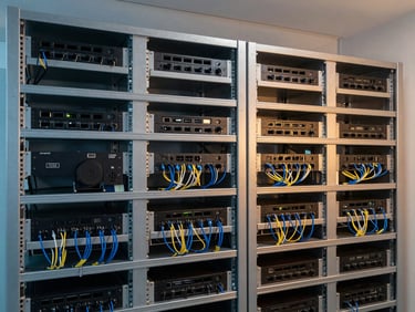 Medium shot of a clean, organized AV rack with neatly cabled equipment in a corporate setting, professional architectural photography.
