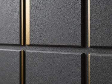 Close-up of a textured charcoal decorative wall cladding panel, showing fine architectural grain and deep tactile shadows under soft side lighting, 35mm