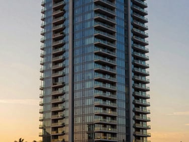 Sleek high-rise luxury apartment tower in Miami, glass and steel structure reflecting sunset sky