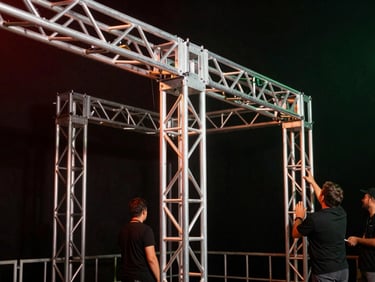 Heavy-duty aluminum stage truss structure, secure joints, backstage crew checking connections under warm work lights