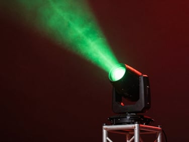 Professional moving head lighting fixture on a stage truss, powerful green light beam cutting through haze, theatrical atmosphere