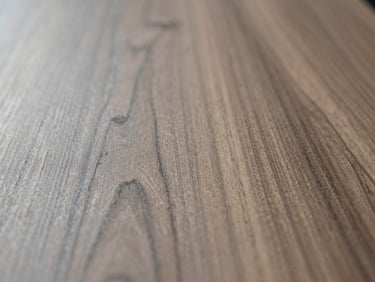 Extreme close-up of premium walnut wood grain, matte finish, soft directional light showing texture