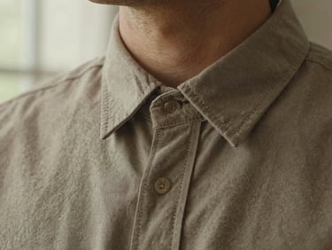 Close-up of a high-quality cotton men's shirt collar, focusing on the neat, millimeter-perfect stitching, soft warm light, editorial photography