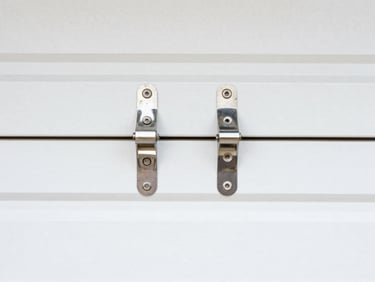 Close-up of new garage door rollers and hinges being installed, sharp focus, clean high-contrast colors