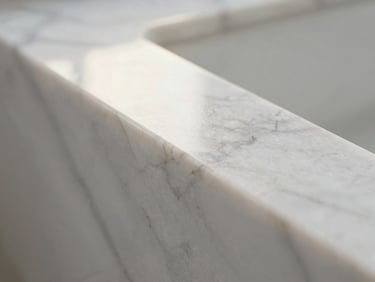 Macro close-up of polished natural white marble reflecting soft morning light, clean lines, serene texture.