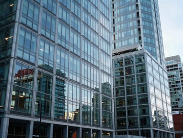 Wide-angle architectural view of modern glass offices in Vancouver, cool natural daylight, reflecting clean geometric lines, no people