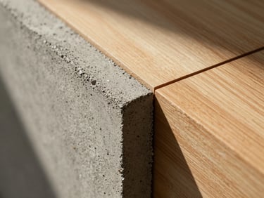 Extreme close-up of raw concrete grain meeting warm timber joins, dramatic chiaroscuro lighting casting sharp geometric lines.