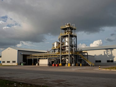 Landscape orientation, industrial dramatic lighting, a modern mineral processing facility or logistics warehouse in Mimika, clean and structured.