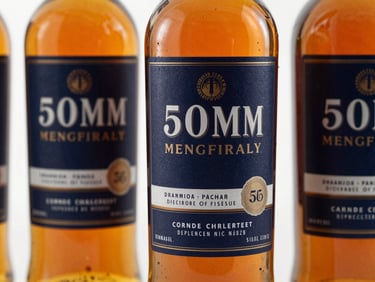 Close-up of premium whisky bottle labels in a clean, high-end studio setting, soft directional key light catching the amber liquid, sharp focus, 50mm