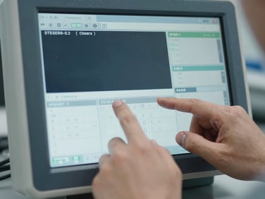 Close-up of an engineer operating diagnostic equipment screen, showing technical data, hands in focus, cool tones.