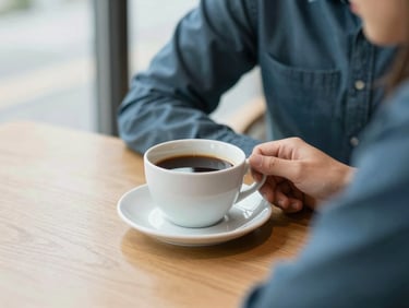 A warm, reassuring scene of a person looking relaxed at a wooden table with a cup of coffee, soft daylight