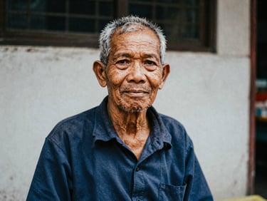 Environmental portrait of an elderly Malaysian street vendor, raw photojournalism, natural light.