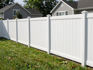 Eye-level shot of a newly installed white vinyl fence in a suburban Westchester backyard, bright daylight, clean lines, green lawn, 35mm lens.