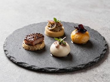 45-degree angle shot of a plated three-course starter arranged on a slate-grey plate, clean daylight from the left, no tablecloth visible, sharp focus on the dish