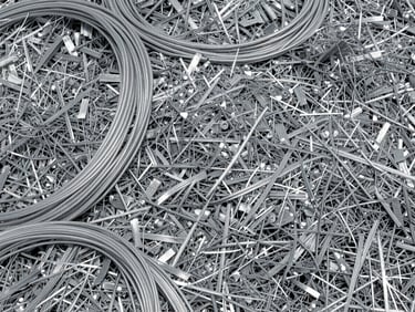 Sorted aluminum scraps and shredded industrial cables, high-contrast metallic shine, realistic grit