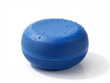 Compact cylindrical blue bluetooth speaker with water droplets, high-key product photography, white background