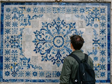 A person admiring intricate mosaic tile work in a historic building, natural daylight, soft blue and cool gray tones, cinematic, 35mm lens.