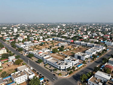 Aerial drone shot of a commercial plot cluster in New Gurgaon showing road access and surrounding infrastructure, midday natural light, minimal cloud cover, no construction activity