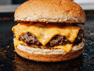 Extreme close-up of a double smash burger with melted cheddar cheese sizzling on a flat-top grill, 35mm gritty street photography.