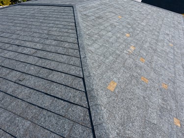 Close-up of flawless shingle alignment on a newly completed dark gray roof, bright natural daylight highlighting the clean structural texture