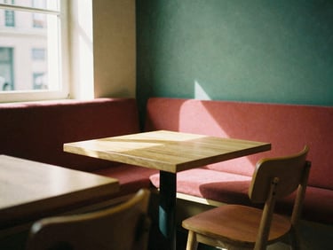 Cozy Scandinavian-style restaurant dining room, soft afternoon window light casting long shadows on minimalist wooden tables, warm editorial photography style, 35mm film look