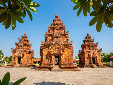 The ancient red brick towers of Po Nagar Cham temple in Nha Trang, framed by green tropical leaves under clear blue sky