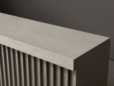 Modern minimalist reception desk with solid surface top and subtle architectural metal panel accents.