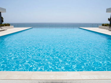 Large upscale condominium pool, perfectly clear blue water, clean minimalist lines, bright daylight