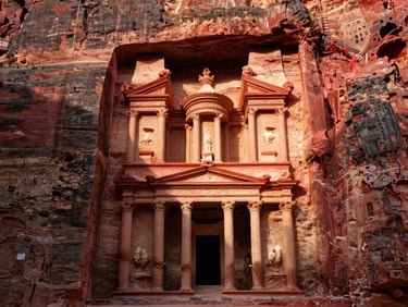 The ancient treasury of Petra carved into red sandstone cliffs, dramatic high-contrast sunlight and deep shadows