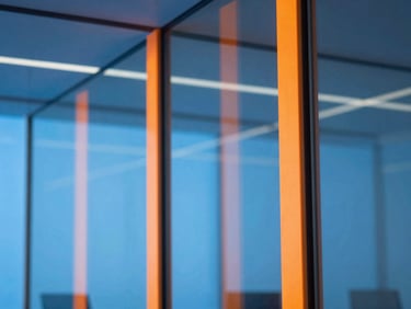 Abstract geometric glass reflections of a modern tech office, crisp high-key studio light with vibrant orange gel accents.