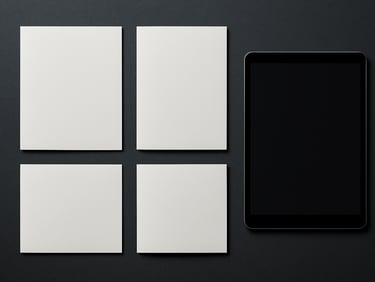 Product flat-lay of printed brochures and a digital display mockup side by side on a dark charcoal surface under even studio light, precise alignment