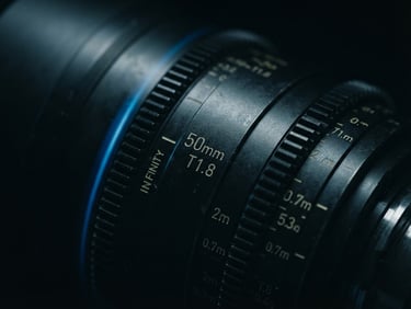 Extreme macro close-up of a high-end cinema camera lens, moody low-key studio lighting with a sharp electric blue edge flare, dark obsidian background.