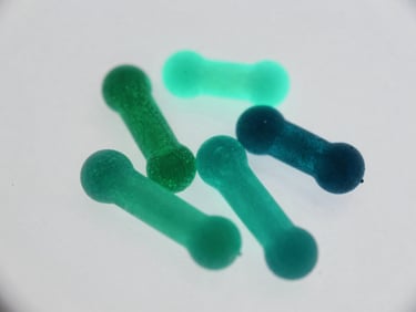 Fluorescent phycobilin proteins glowing bright cyan and emerald under ultraviolet laboratory light, scientific macro photography.