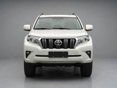 Head-on front-angle shot of a white Toyota Land Cruiser Prado on a clean grey studio floor, neutral temperature lighting, no people, badge and bumper detail crisp