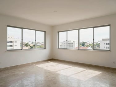 Wide interior shot of a bright Accra apartment living room, natural light through large windows, clean walls and tiled floor, no people, showing actual scale and condition